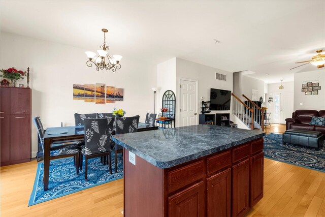 kitchen featuring visible vents, pendant lighting, dark countertops, open floor plan, and light wood-style flooring
