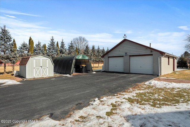 detached garage featuring a shed