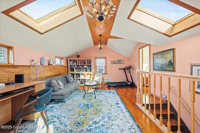 living room with an inviting chandelier, dark hardwood / wood-style floors, and vaulted ceiling with skylight