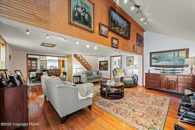 living room with rail lighting, hardwood / wood-style floors, and high vaulted ceiling