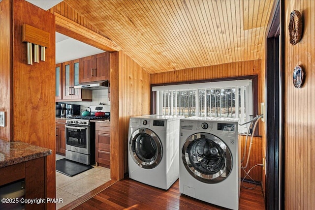 laundry area featuring hardwood / wood-style flooring, washer and clothes dryer, wooden ceiling, and wooden walls