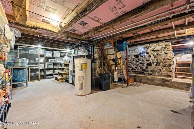 unfinished basement with stairway and electric water heater