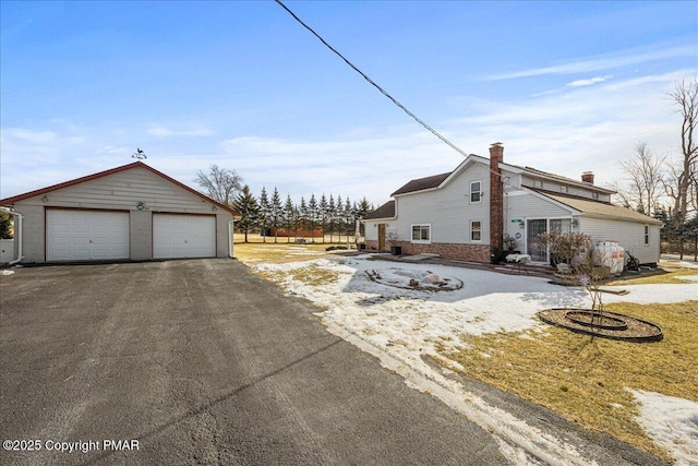 view of side of property with a detached garage and an outdoor structure