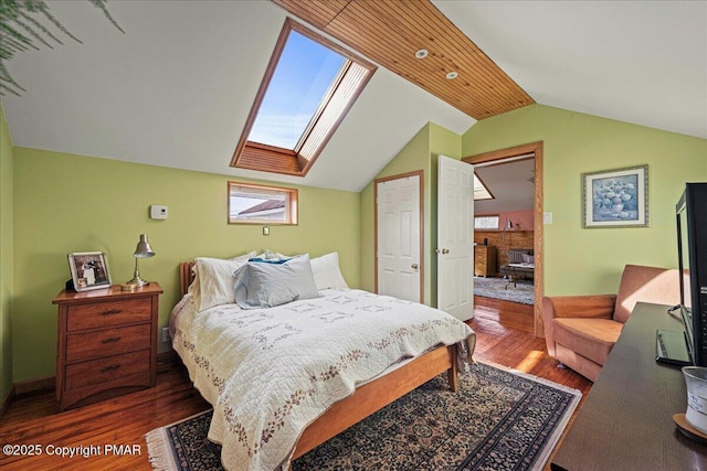 bedroom with dark wood-type flooring and vaulted ceiling with skylight