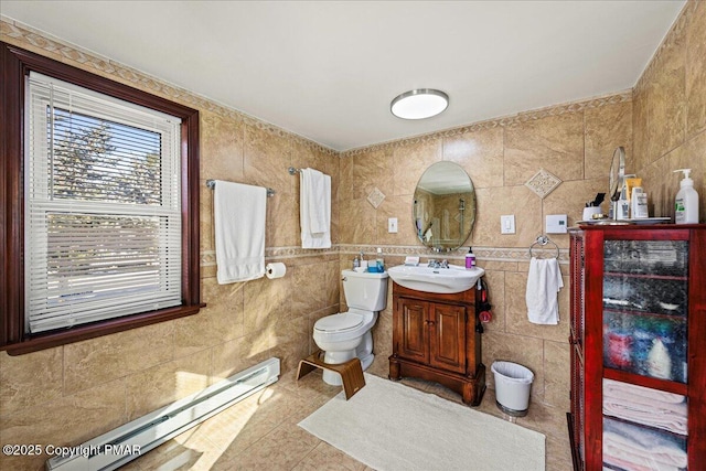 bathroom featuring toilet, a baseboard radiator, tile patterned flooring, vanity, and tile walls