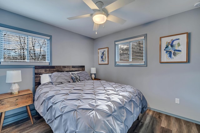 bedroom with a ceiling fan, baseboards, and wood finished floors