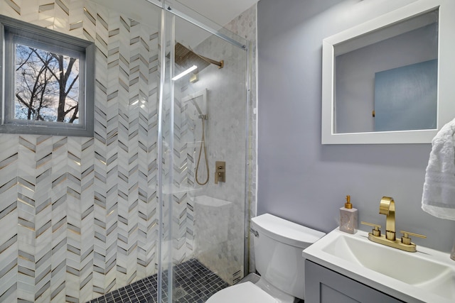 bathroom with a stall shower, vanity, and toilet