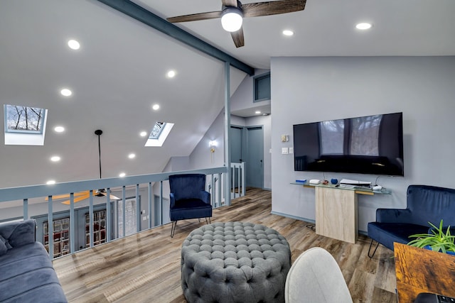 living area with lofted ceiling with skylight, recessed lighting, ceiling fan, and wood finished floors