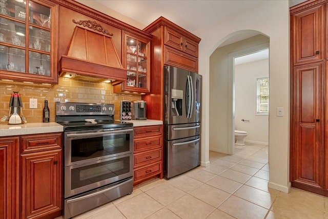 175 Wyndham Dr, Cresco, PA 18326 - kitchen featuring stainless steel appliances, arched walkways, premium range hood, and light countertops