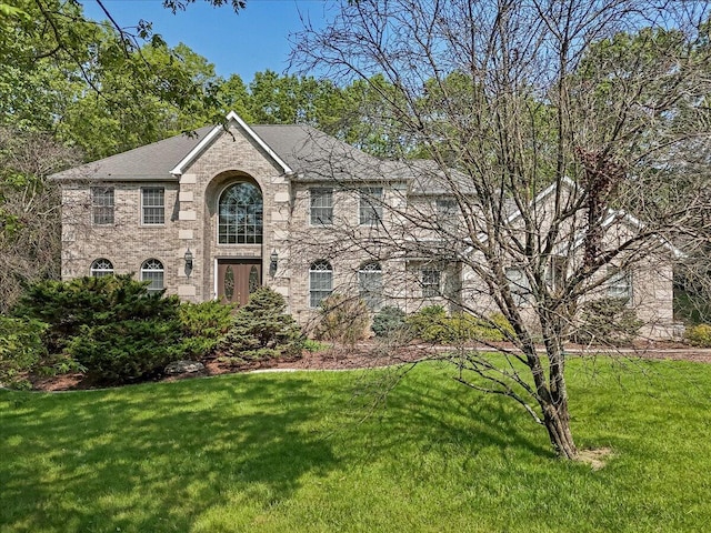 175 Wyndham Dr, Cresco, PA 18326 - view of front of home with a front yard, a shingled roof, and brick siding