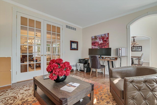 175 Wyndham Dr, Cresco, PA 18326 - living room with a chandelier, wood finished floors, crown molding, french doors, and arched walkways