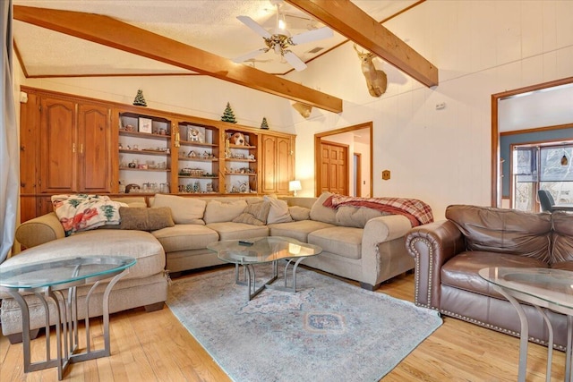 living room with lofted ceiling with beams, light wood-style flooring, and a ceiling fan