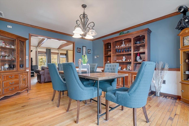 dining space featuring a notable chandelier, baseboards, crown molding, and light wood-style floors