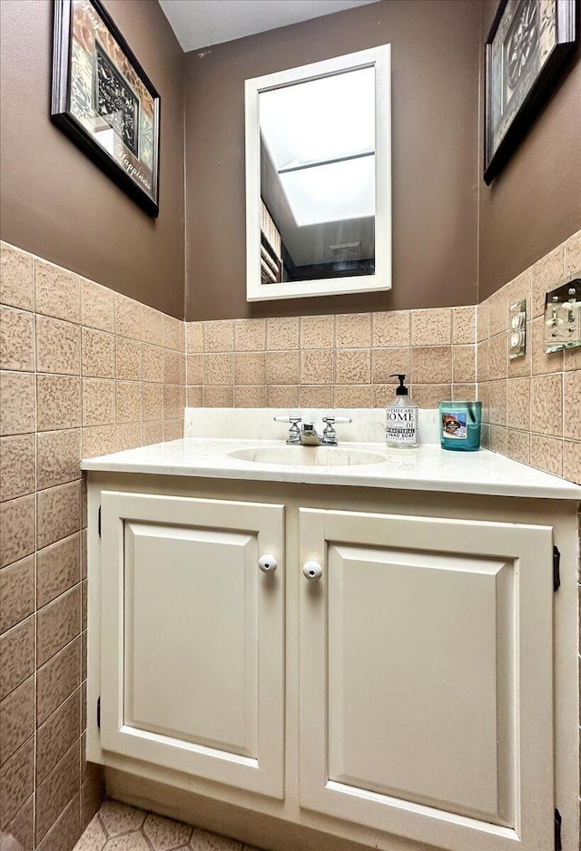 bathroom with a wainscoted wall, tile walls, and vanity