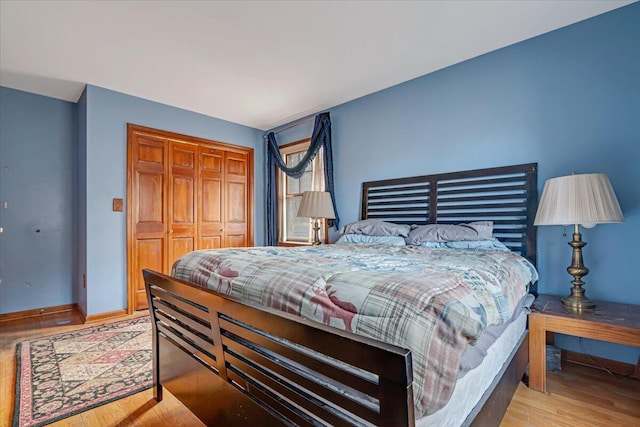 bedroom featuring a closet, baseboards, and wood finished floors