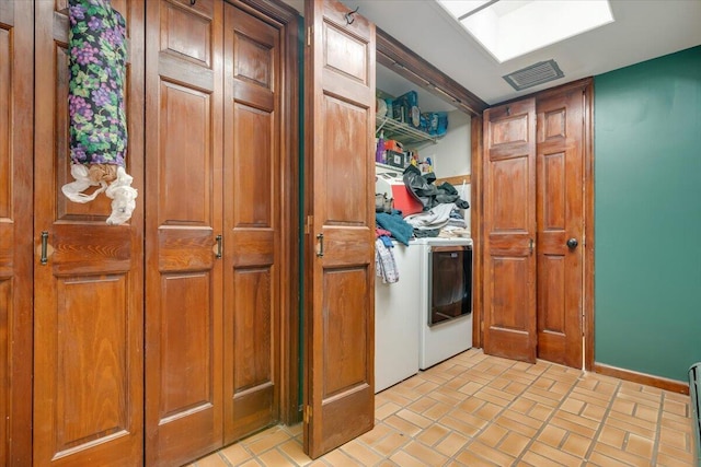 laundry area featuring visible vents, laundry area, a skylight, brick floor, and independent washer and dryer