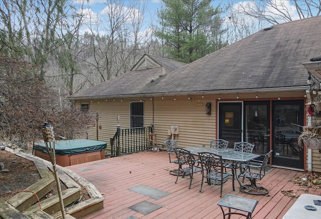 wooden deck with a covered hot tub and outdoor dining area