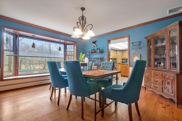 dining space with visible vents, ornamental molding, light wood-style flooring, baseboard heating, and a chandelier