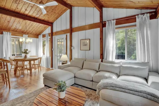 living area with ceiling fan with notable chandelier, wooden ceiling, and lofted ceiling with beams