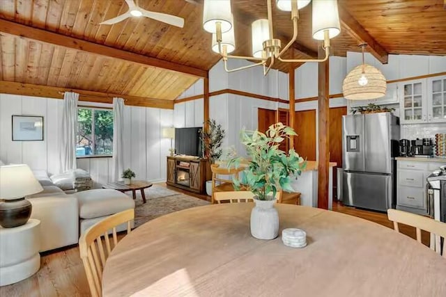 dining area featuring wooden ceiling, lofted ceiling with beams, a fireplace, and light wood finished floors