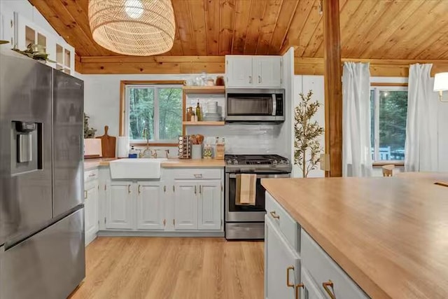 kitchen with wood ceiling, appliances with stainless steel finishes, light wood-style flooring, and a sink