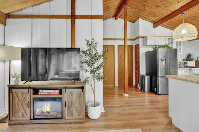 kitchen with wooden ceiling, light wood-style flooring, stainless steel fridge with ice dispenser, and beamed ceiling