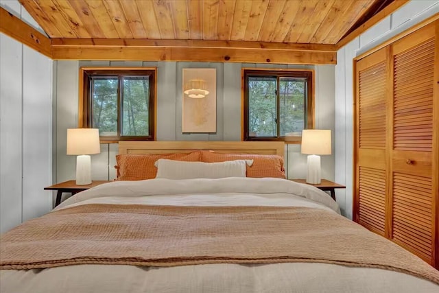 bedroom with a closet, wooden ceiling, and vaulted ceiling