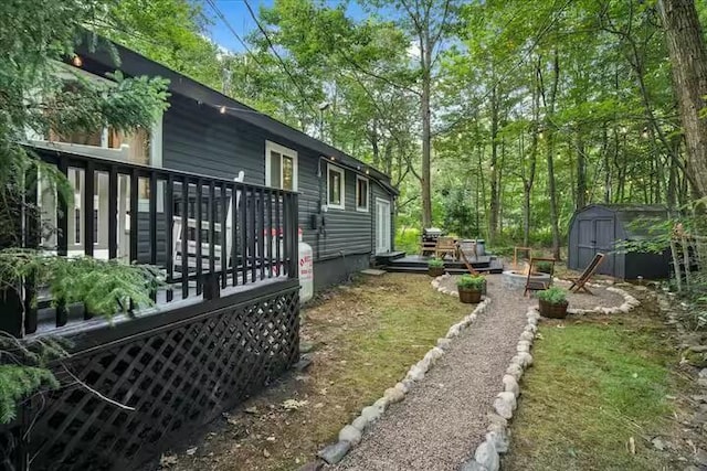 view of yard with an outbuilding, a storage unit, and a wooden deck