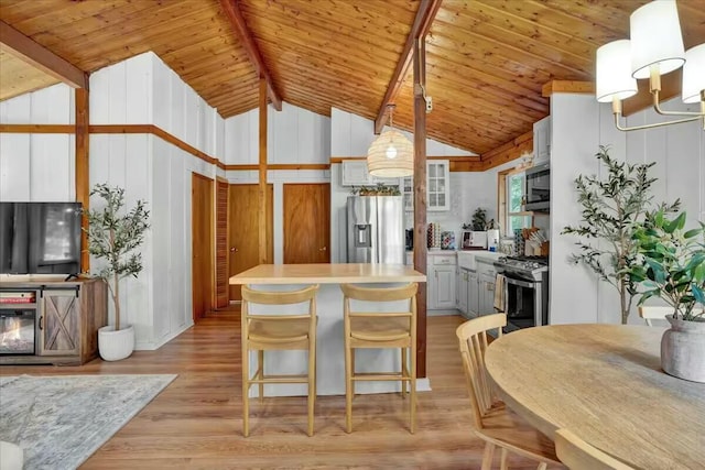 kitchen with a kitchen island, light wood-type flooring, light countertops, wooden ceiling, and stainless steel appliances