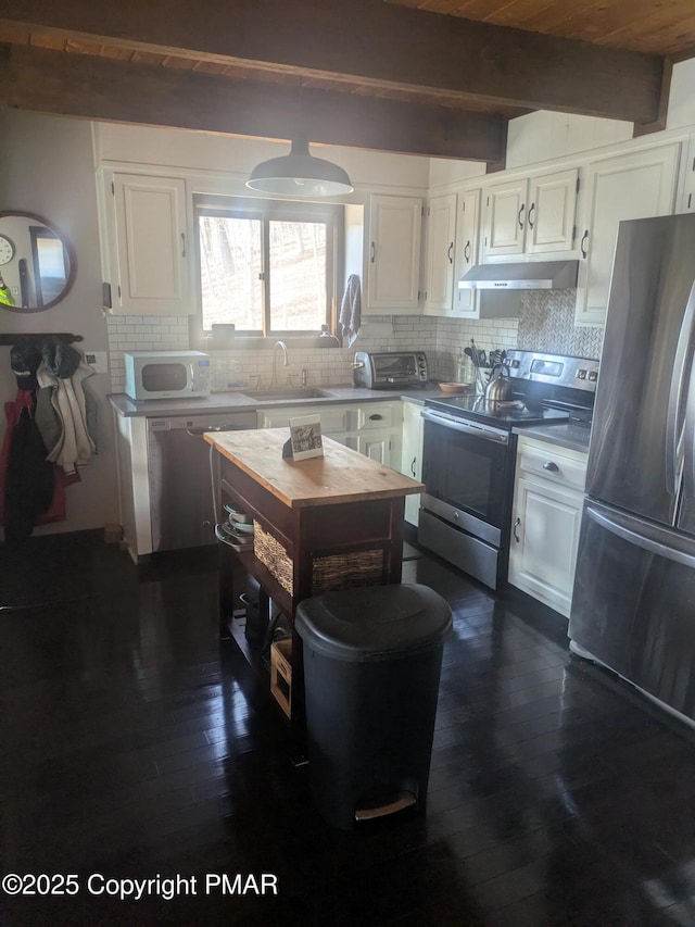 kitchen featuring under cabinet range hood, a sink, white cabinetry, appliances with stainless steel finishes, and tasteful backsplash