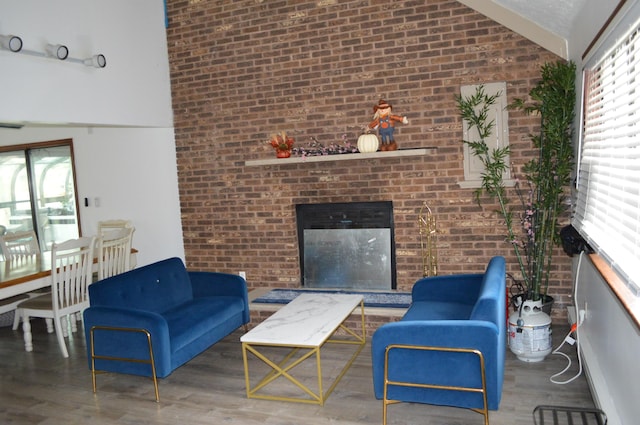 6372 Baltic Ave, Tobyhanna, PA 18466 - living area featuring brick wall, wood finished floors, a brick fireplace, and high vaulted ceiling