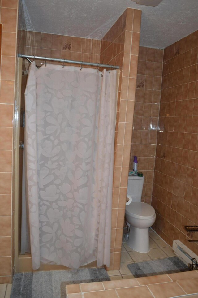 6372 Baltic Ave, Tobyhanna, PA 18466 - bathroom featuring a baseboard heating unit, toilet, a stall shower, tile patterned floors, and a textured ceiling