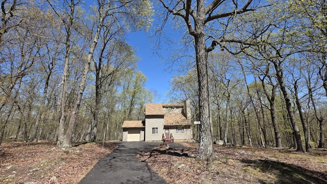 view of front of property with a garage, roof with shingles, and aphalt driveway