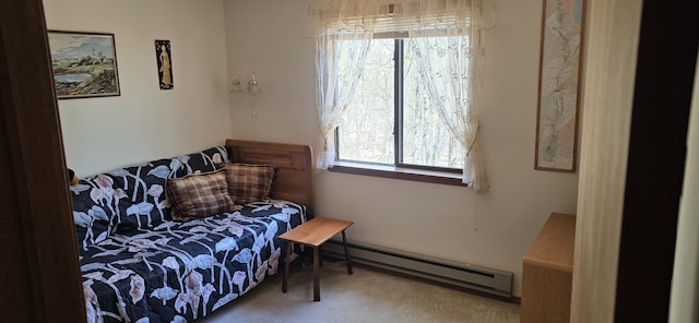 sitting room with carpet flooring, a baseboard heating unit, and a healthy amount of sunlight