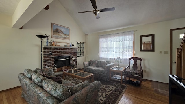 living area with a brick fireplace, hardwood / wood-style floors, a ceiling fan, baseboards, and vaulted ceiling