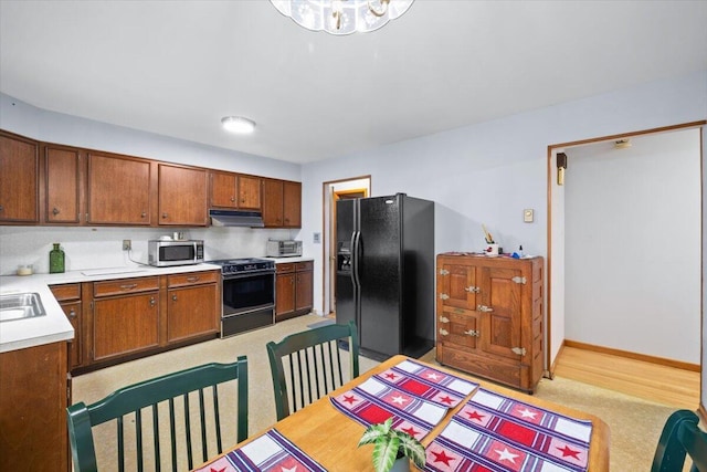 126 Keystone Ln, Tobyhanna, PA 18466 - kitchen featuring stainless steel appliances, range hood, light countertops, brown cabinets, and a chandelier