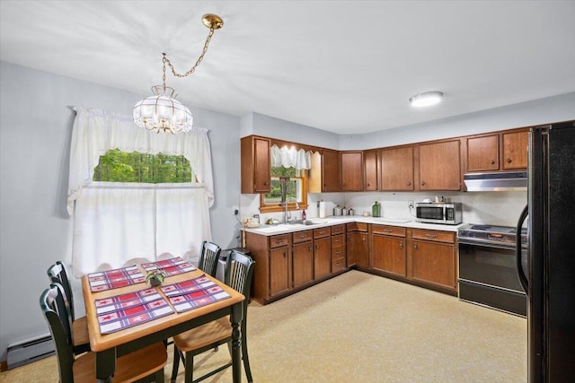 126 Keystone Ln, Tobyhanna, PA 18466 - kitchen with range, under cabinet range hood, stainless steel microwave, brown cabinetry, and a chandelier