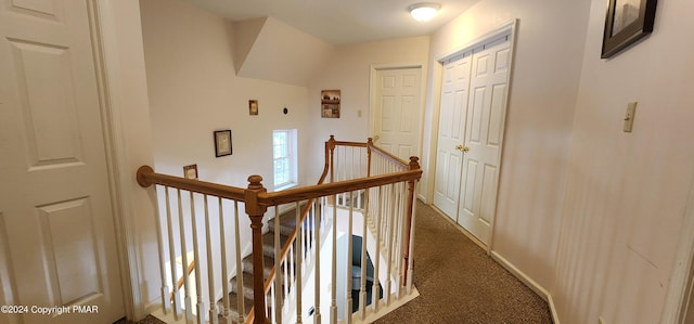 hall featuring carpet, an upstairs landing, and baseboards