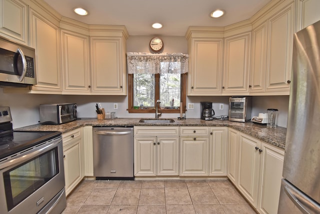 248 Miller Dr, Pocono Pines, PA 18350 - kitchen featuring recessed lighting, cream cabinetry, light tile patterned floors, a sink, and appliances with stainless steel finishes