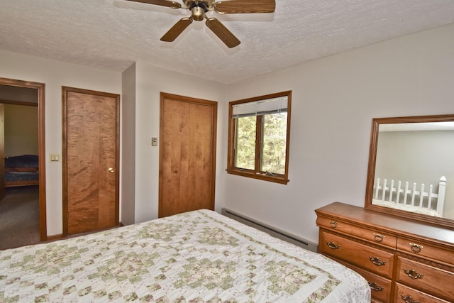 248 Miller Dr, Pocono Pines, PA 18350 - bedroom featuring baseboard heating, a textured ceiling, multiple closets, and a ceiling fan