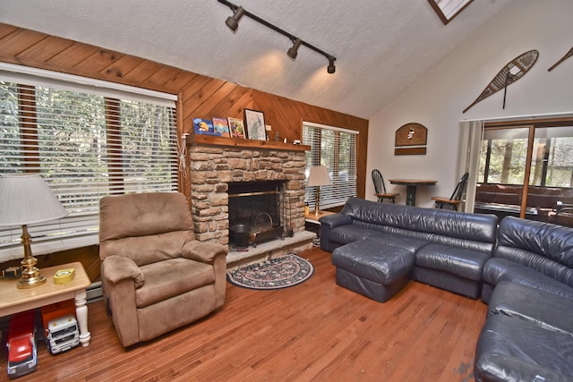 248 Miller Dr, Pocono Pines, PA 18350 - living room featuring track lighting, high vaulted ceiling, wood finished floors, wooden walls, and a fireplace