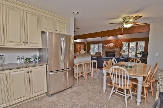 248 Miller Dr, Pocono Pines, PA 18350 - dining area featuring vaulted ceiling with beams, wood walls, ceiling fan, a stone fireplace, and light tile patterned floors