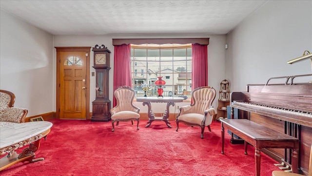 sitting room featuring carpet flooring, a textured ceiling, and baseboards