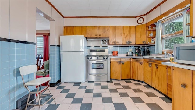 kitchen featuring crown molding, light floors, light countertops, appliances with stainless steel finishes, and open shelves