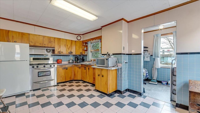 kitchen with light floors, appliances with stainless steel finishes, open shelves, and ornamental molding