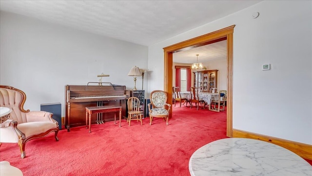 sitting room featuring baseboards, carpet, and an inviting chandelier