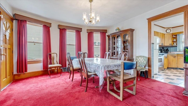 dining room featuring a chandelier, light colored carpet, and light floors