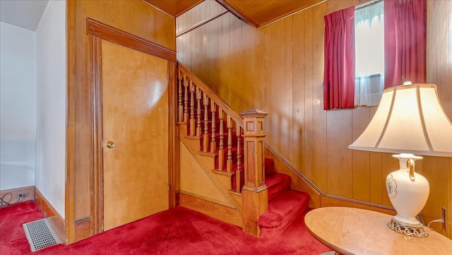 staircase with visible vents and wood walls