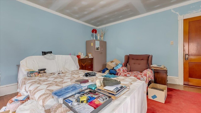 bedroom featuring baseboards, wood finished floors, and ornamental molding