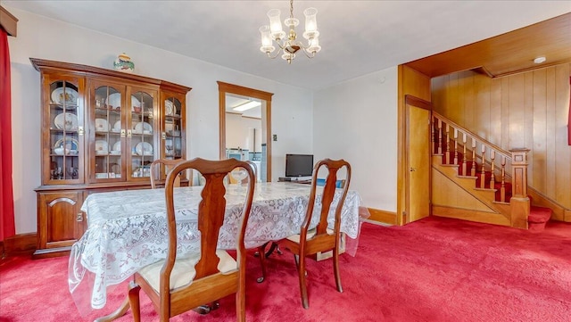 dining area featuring stairs, a notable chandelier, and carpet flooring